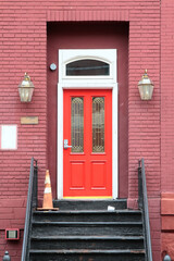 Red vintage wooden entry door with combination lock, white framing and segmental arch. New Jersey. USA.