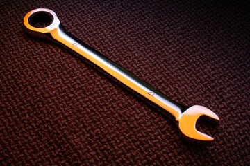 Spanner highlighted with orange light on canvas background