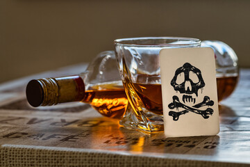 Whiskey bottle and glass with death card