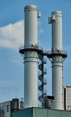 corkscrew staircase with huge power plants under the blue sky