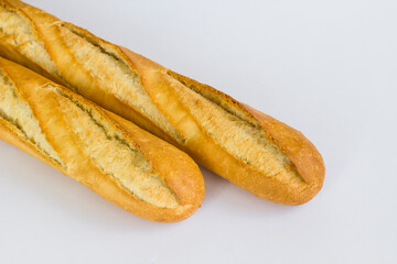 Fresh baguette breads on white surface with knife,above view.