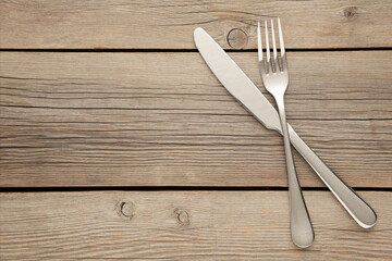 Fork and knife with copy space on a grey wooden background
