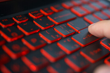 Red backlit computer keyboard macro shot of enter key