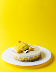 Raw cashew cake with mango and coconut on a yellow background. Sugar, lactose, gluten free. Healthy food, vegan.