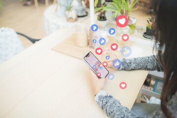 selective focus. soft focus. Young women using smartphones In a coffee shop or restaurant. Concept : applications that enable users to create and share content or to participate in social networking.