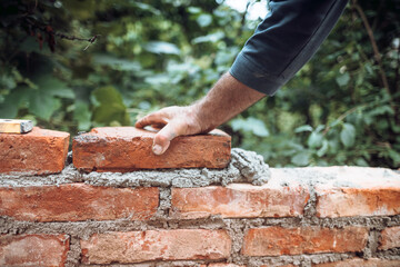 industry details - Construction bricklayer worker building walls with bricks, mortar and putty...