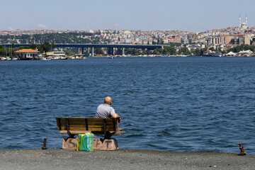 A man contemplate the Bosporus strait from the Asian side of Istanbul, Turkey, during a hot summer day.