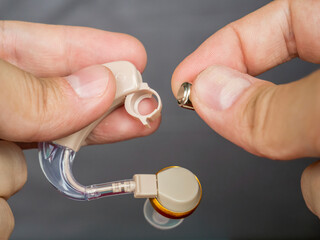 Man's hands changing a hearing aid battery