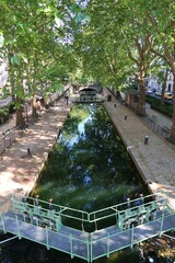 Écluse sur le canal Saint-Martin bordé d’arbres, à Paris,
en été (France)