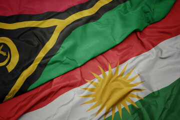 waving colorful flag of kurdistan and national flag of Vanuatu .