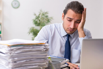 Young male businessman employee unhappy with excessive work