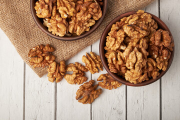 Walnut kernels on a wooden background.