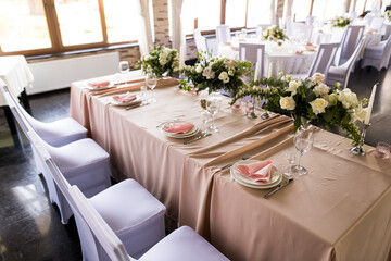 Presidium table setting with empty wineglasses. Selebration banquet with plates and wineglasses for white or red wine on the pink table in restaurant