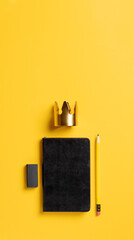content is king for online marketing concept.top view of black notebook with golden crown and pencil on yellow table background,vertical banner for advertising on mobile media