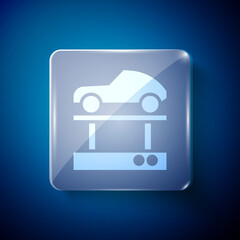 White Repair car on a lift icon isolated on blue background. Repair of the underbody, suspension, wheels and engine. Square glass panels. Vector Illustration.