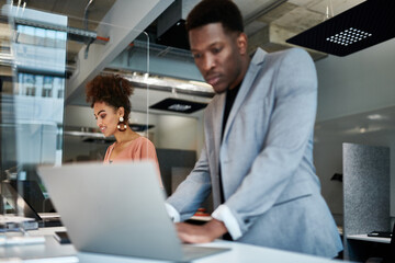 Smiling female design professional working by male colleague at creative workplace