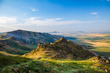 Mountain peak and valley bellow landscape under blue sky, vertical view, side lighting, in the...