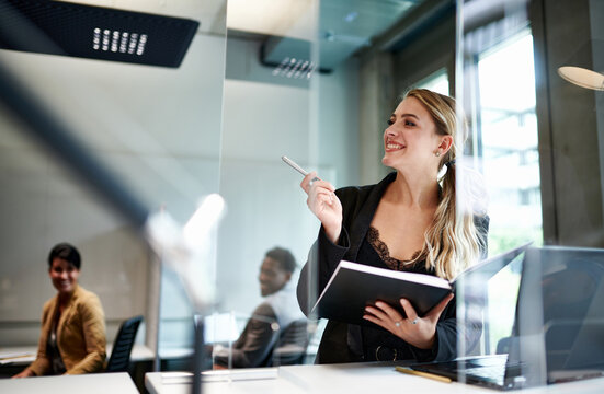 Cheerful Attractive Female Design Professional Looking Away While Holding Book At Workplace During Coronavirus