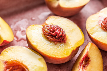 Fresh and juicy peaches halved and sliced. Close-up view.