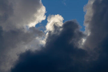 Fototapeta premium Dark cumulus clouds. A piece of blue sky. Natural background.