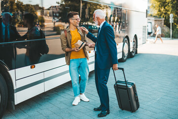 Obraz premium The bus driver accepts luggage from passenger.