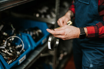Handsome adult man working in car and truck spare parts warehouse.