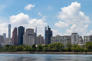 Fototapeta na wymiar Skyline of Roosevelt Island with the Manhattan Skyline in the Background during Summer along the East River