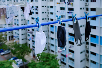 Reusable masks washed and hung on laundry pole to dry;  eco-friendly, reusable homemade cloth...