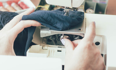 
Seamstress hands adjust sewing machine