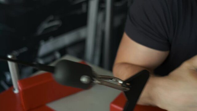 A healthy athlete trains on an exercise machine in the gym and prepares for amresling. Blue caucasian man. Sport