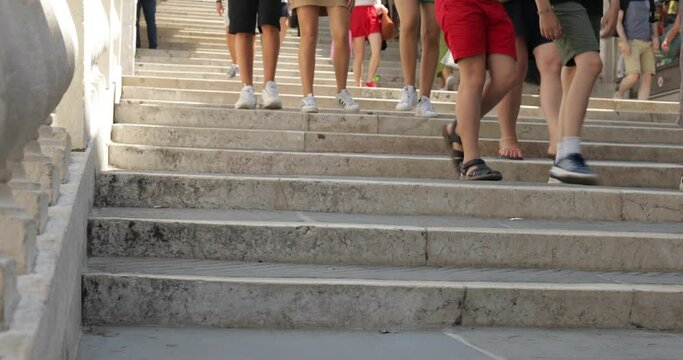 Turisti che scendono e salgono i gradini dei ponti a Venezia