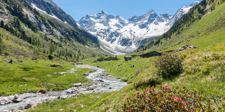 Landschaftspanorama mit Gletscher Gebirgsbach und Almhütten in Tirol Österreich