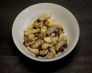 The worm beetle of Red palm weevil (Red-stripes palm weevil, Sago palm weevil, Rhynchophorus ferrugineus) ready to eat. It is one of the best Asian food and popular for the tourist.