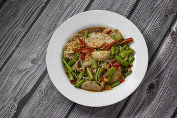 Top view of Spicy lemongrass flavored noodle soup with marinated pork chops and fried wontons (side dish)