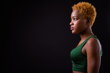 Young beautiful African woman against black background