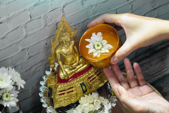 The hand spinkle water onto a Buddha statue on Song kran day 2020 (Thai new year) at home while lockdown in town because corona virus
