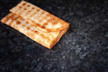 One cookie on black marble. Freshly baked product. Selective soft focus.