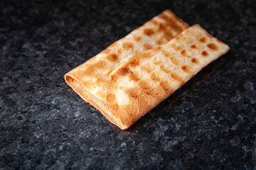 One ruddy biscuits on black marble. Freshly baked product.