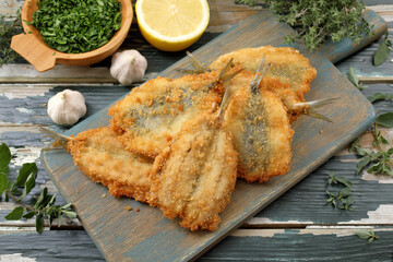 pesce sarde fritte su tagliere di legno