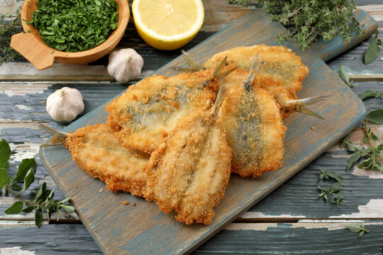 pesce sarde fritte su tagliere di legno