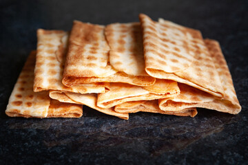 Ruddy dry crispy biscuits stacked on black marble. Freshly baked cookies.