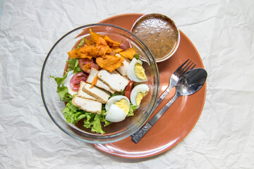 Top view of Thai style Muslim salad that include tofu, boiled egg , crispy sweet potato, and vegetables with peanut dressing