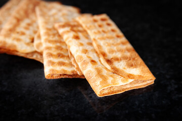 Three fried crispy cookies stacked on a black background. Freshly baked cookies.
