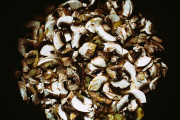 Background of cooked mushrooms in sunflower oil in a frying pan