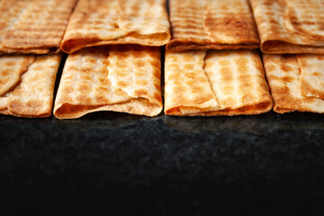 Crunchy biscuits stacked on black marble. Freshly baked cookies. Selective soft focus.