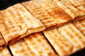 Close-up of hot crispy biscuits piled on black marble. Freshly baked cookies.