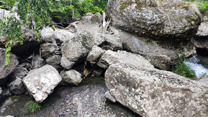 Ufa, Russia July 20, 2020 water flows between large stones in the middle of the forest