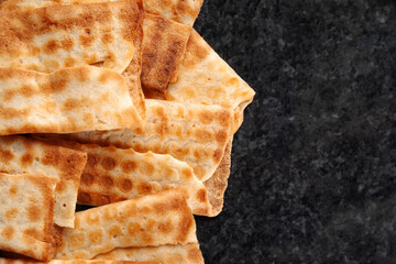 Top view of hot crispy cookies stacked on black marble. Freshly baked cookies. Selective soft focus.