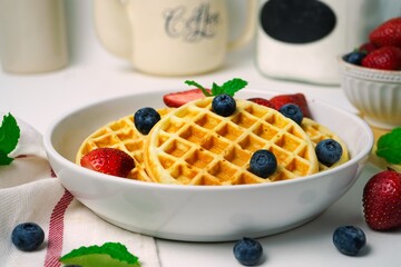 Homemade Mini Waffles topped with fresh berries, selective focus