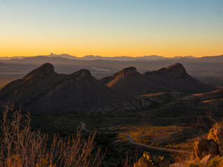 A row of 4 jagged desert mountains at sunset